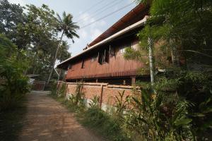 a barn with a dirt road in front of it at Panackal Heritage Home in Trivandrum