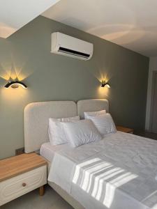 a bedroom with a bed and a air conditioner on the wall at Fethiye Serenity Suites in Fethiye