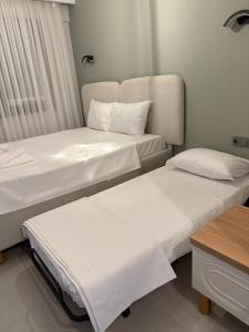 two beds in a hotel room with white sheets at Fethiye Serenity Suites in Fethiye +15 photos