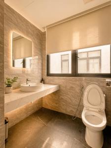 a bathroom with a toilet and a sink and a mirror at SOLÉRA 2 Homestay in Phú Quốc