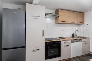 a kitchen with white cabinets and a stove top oven at MK Rooms Bremen in Bremen