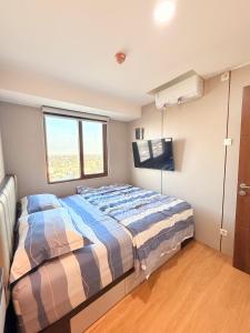 a bedroom with a bed and a window at SkyBreeze Sentraland in Medan