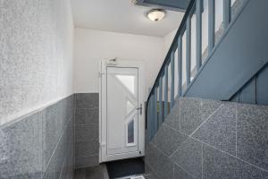 a hallway with a white door and a staircase at MK Rooms Bremen in Bremen +14 photos