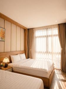 a hotel room with two beds and a window at SOLÉRA 2 Homestay in Phú Quốc +15 photos