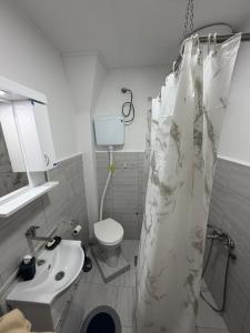 a bathroom with a shower curtain and a sink at Apartman Velić in Bor