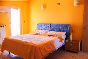 a bedroom with a bed with an orange wall at B&B Ad Un Passo Dal Mare in Montesilvano