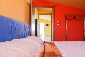 a bedroom with a bed and a red wall at B&B Ad Un Passo Dal Mare in Montesilvano