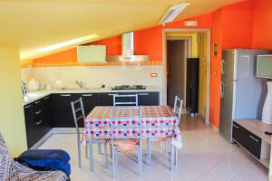a kitchen with a table with chairs and a refrigerator at B&B Ad Un Passo Dal Mare in Montesilvano
