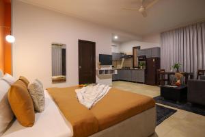 a bedroom with a large bed and a living room at Studio Serviced Apartments near Fortis Hospital in Gurgaon