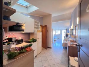 a kitchen with white cabinets and a sink at Dimora le tagliate in Lucca