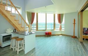 a kitchen with a staircase and a kitchen with stools at Daecheon Mud Gongju Pension in Boryeong +3 photos