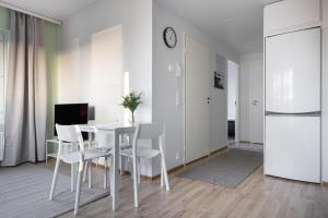 a white dining room with a table and chairs at Spot Apartments Oulu in Oulu