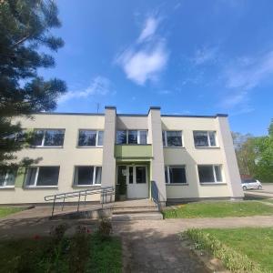 a white building with a bench in front of it at Nemunėlio vitražai in Nemunėlio Radviliškis
