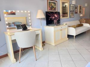a room with a desk with a chair and a table with a laptop at Dimora le tagliate in Lucca