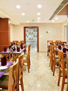 a dining room with wooden tables and chairs at Hotel Sea Blue MALLAPPALLY in Vennikulam