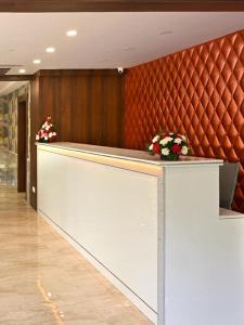 a lobby with a counter with flowers on it at Hotel Sea Blue MALLAPPALLY in Vennikulam