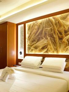 a bedroom with a bed with a painting on the wall at Hotel Sea Blue MALLAPPALLY in Vennikulam +6 photos