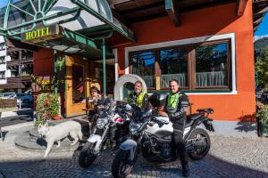 three men sitting on motorcycles in front of a hotel at Hotel Tiroler Adler - bed and breakfast in Waidring +37 photos