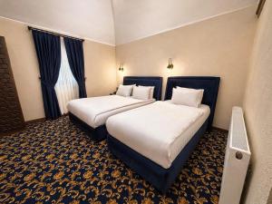 a hotel room with two beds and a window at Rüstempaşa Kervansaray Hotel with Free Parking in Edirne