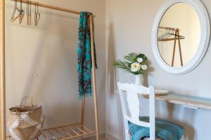 a bathroom with a mirror and a white chair at Family Heritage Homes- Skiathos in Skiathos +62 photos