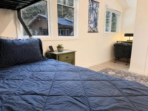 a bedroom with a blue bed and a window at Boho Burrow in Monte Rio