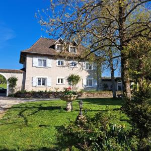 a large white house with a garden in the yard at Charmante maisonnette avec piscine partagée in Charancieu