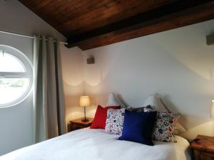 a bedroom with a bed with pillows on it at Charmante maisonnette avec piscine partagée in Charancieu +17 photos
