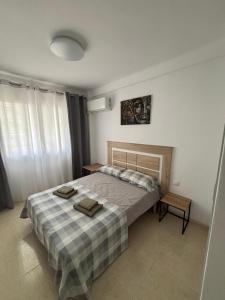 a bedroom with a bed with two towels on it at Tropical Salou in Salou