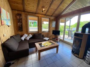 a living room with a couch and a tv at Extertal-Ferienpark - Sonnenhügel in Extertal