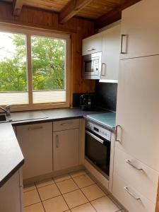 a kitchen with white cabinets and a window and a stove at Extertal-Ferienpark - Sonnenhügel in Extertal