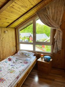 a bed in a room with a large window at Extertal-Ferienpark - Sonnenhügel in Extertal