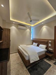 a bedroom with a large bed with a ceiling at Hotel LimeStarow in Bijni