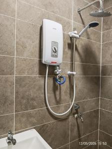 a shower in a bathroom with a soap dispenser on a wall at JN Villa Homestay 5 Bedroom house, Near Airport Kota Kinabalu in Donggongon +32 photos