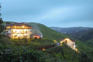 a large house on a hill with a road at Monkey Tribe Vagamon in Vagamon +16 photos