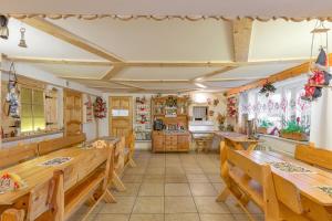 a dining room with wooden benches and a kitchen at Topaz in Karpacz