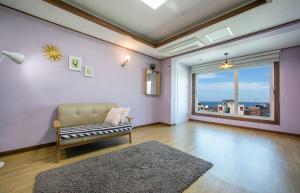 a living room with a couch and a large window at Pension Ora in Samcheok +10 photos