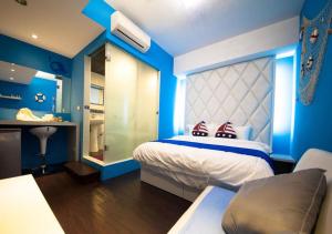 a bedroom with blue walls and a bed with red pillows at 羅東簡單住一晚 in Luodong +14 photos