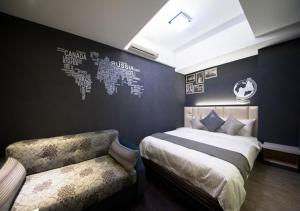 a bedroom with a bed and a bench and a wall at 羅東簡單住一晚 in Luodong