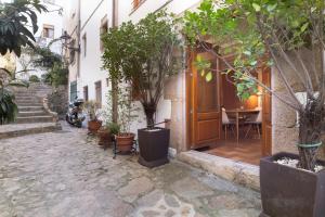 a street with a house with a table and potted trees at LETS HOLIDAYS NICE HOUSE CLOSE to the CASTLE in Tossa de Mar