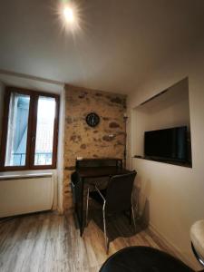 a room with a table and a clock on a wall at L'aube de Pierre in Saint-Pons-de-Thomières