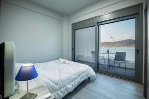 a bedroom with a bed and a view of the water at Sea Breeze Stay 1 in Salamina
