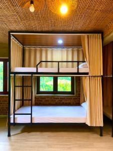 two bunk beds in a room with a window at Nếp homestay in Làng Xa