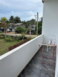 a chair on the balcony of a house at Ocean Heart Guest House in Nilaveli +21 photos