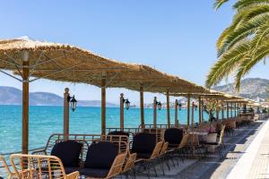 a row of chairs and umbrellas on the beach at Sea Breeze Stay 1 in Salamina