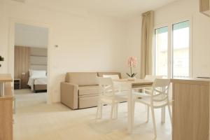 a kitchen and living room with a table and chairs at Hotel Mariblu in Rimini