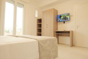 a bedroom with a bed and a tv on a wall at Hotel Mariblu in Rimini