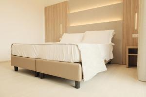 a bedroom with a bed with white sheets and pillows at Hotel Mariblu in Rimini