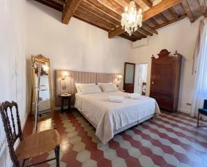 a bedroom with a large bed and a chandelier at Dimora Decò in Lugo