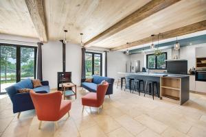 a kitchen and living room with blue chairs and a counter at Lou Papagai in Saint-Antonin