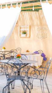 a group of tables and chairs in a room at Salento Ada's House in Melendugno